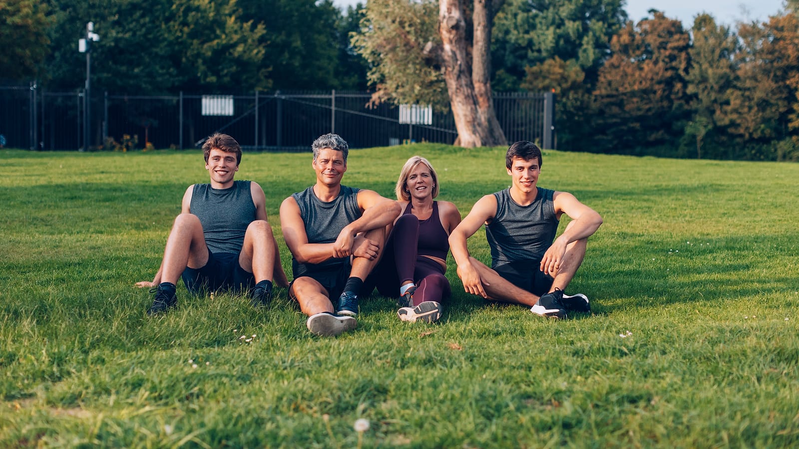 Gruppe sitzt nach dem gemeinsamen Training auf einer Wiese in Münster