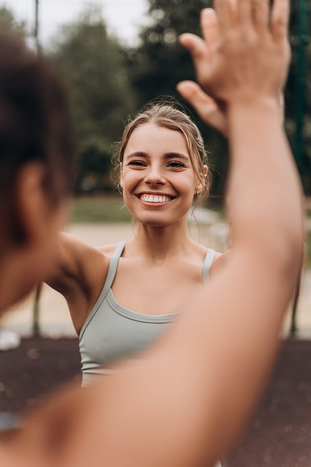 Zwei Trainierende klatschen sich nach dem Training draußen ab