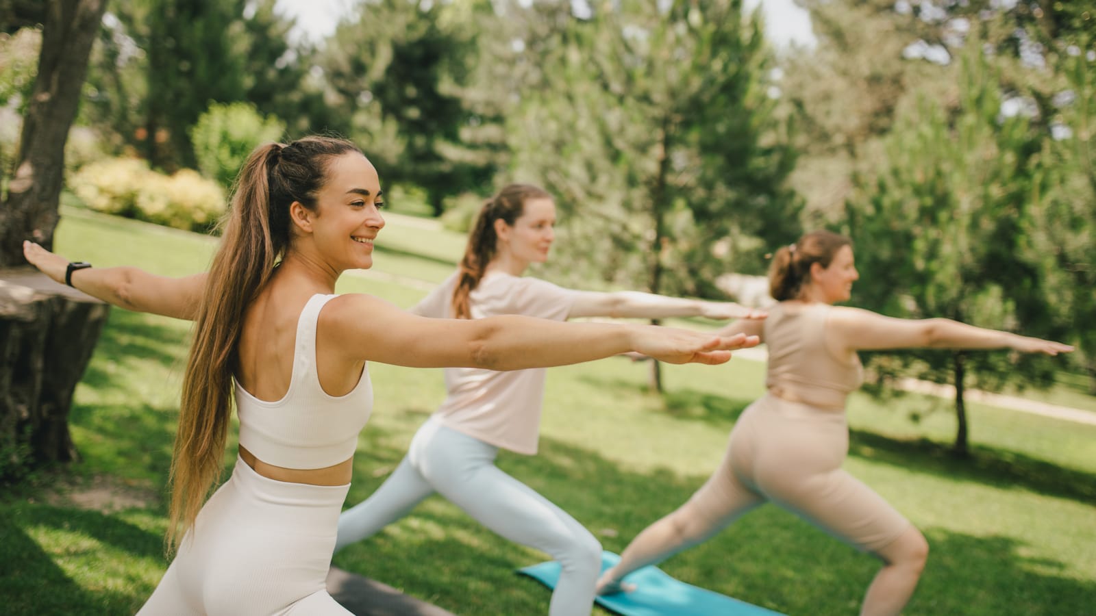 Yoga-Gruppe im Freien in Münster in der Krieger-Haltung